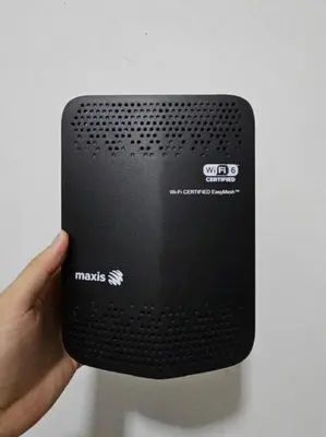 a persons hand holding a black speaker with the word marks on it at My Muji Homestay I Massage Chair I Wifi 500 Mbps in Seri Manjung