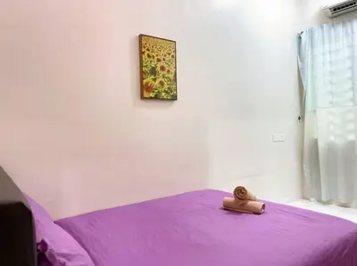 a teddy bear sitting on top of a purple bed at CozyHouse 4ROOM 3BATH ROOM 10PAX```SimpangAmpatTasek in Simpang Ampat