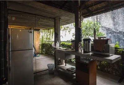 a kitchen with a refrigerator and a table with a microwave at Belakang Kong Heng Ipoh Hotel in Ipoh