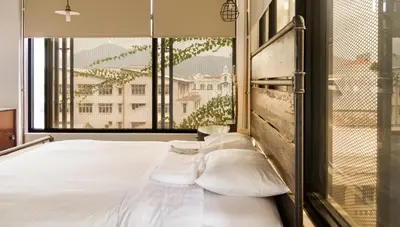 a bedroom with a bed with pillows and a window at Belakang Kong Heng Ipoh Hotel in Ipoh