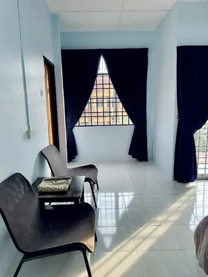 a room with a chair and a table and a window at D Ocean Homestay in Seri Manjung
