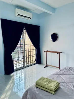 a bedroom with a bed with a table and a window at D Ocean Homestay in Seri Manjung