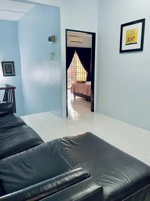 a bedroom with a black leather couch in a room at D Ocean Homestay in Seri Manjung