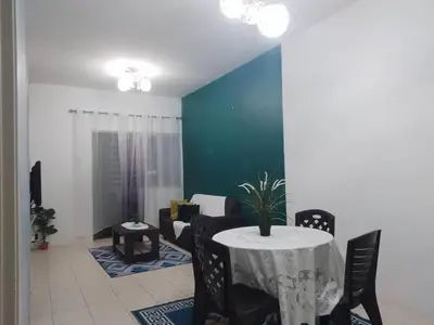 a dining room with a table and a couch at Apartment Cameron Jaya in Tanah Rata
