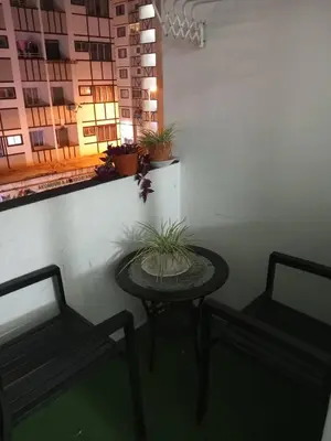 a patio with two benches and a table with a plant at Apartment Cameron Jaya in Tanah Rata