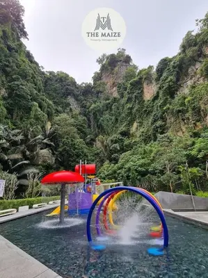 a water park with a water slide in front of a mountain at The Cove Hillside Residence Ipoh - Downtown Delight in Ipoh
