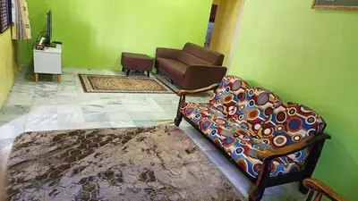 a living room with a couch and a chair at Homestay Kak Rose Kuala Lipis in Kuala Lipis
