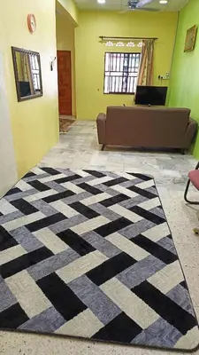 a living room with a black and white rug at Homestay Kak Rose Kuala Lipis in Kuala Lipis
