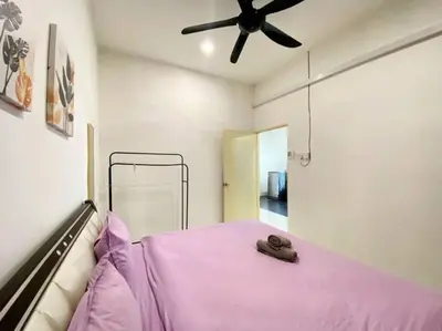 a bedroom with a pink bed with a ceiling fan at Cozy House 3Room8Pax`````LUNAS in Lunas