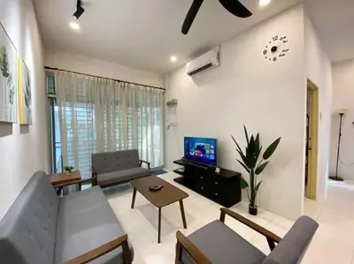 a living room with a couch and a tv at Cozy House 3Room8Pax`````LUNAS in Lunas