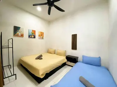 a bedroom with two beds and a ceiling fan at Cozy House 3Room8Pax`````LUNAS in Lunas