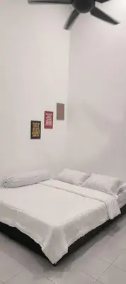 a bed with a ceiling fan in a room at Homestay Manjung HZ in Sitiawan