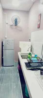 a kitchen with a sink and a white refrigerator at Homestay Manjung HZ in Sitiawan
