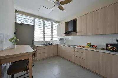 a kitchen with wooden cabinets and a ceiling fan at Simple Sanctuary Tanjung Tokong in Tanjung Bungah