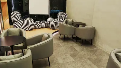a group of chairs and tables in a room at 12 pax luxury seaview infinity pool apartment in Jelutong
