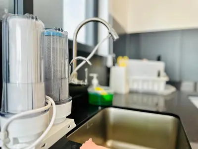 a kitchen counter with a sink and a mixer at 12 pax luxury seaview infinity pool apartment in Jelutong