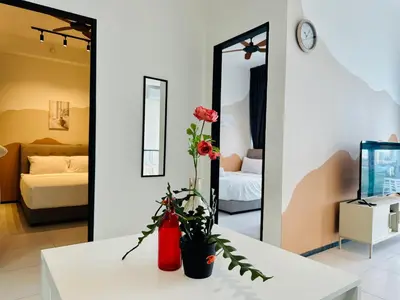 a room with a white table with a vase with flowers at 12 pax luxury seaview infinity pool apartment in Jelutong