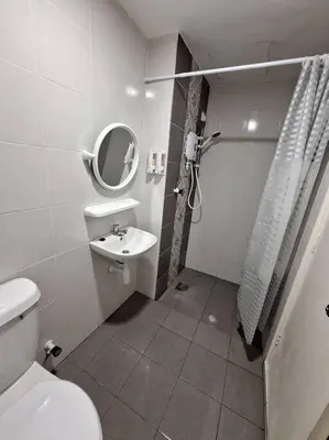 a bathroom with a toilet and a sink and a mirror at Anderson Zara Homestay in Ipoh