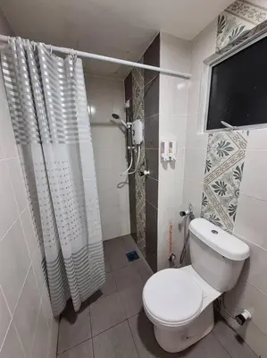 a white bathroom with a toilet and a shower at Anderson Zara Homestay in Ipoh