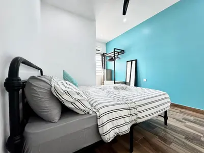 a bedroom with a bed and a blue wall at i Homes Villa 2 at Ipoh Town 16 Guest in Ipoh