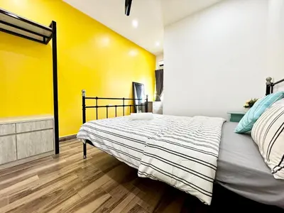a bedroom with a bed and a yellow wall at i Homes Villa 2 at Ipoh Town 16 Guest in Ipoh
