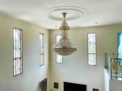 a living room with a chandelier and a fireplace at Bungalow in exclusive area in Nibung Tebal
