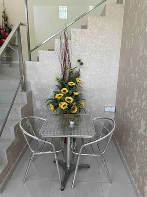 a table with chairs and a vase of flowers on it at Bungalow in exclusive area in Nibung Tebal
