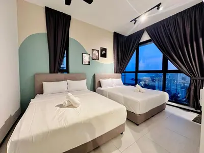 two beds in a room with large windows at 2 bed room 5 queen bed luxury sea view apartment in Jelutong