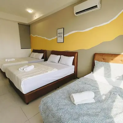 two beds in a hotel room with two bedsskirts at 2 bed room 5 queen bed luxury sea view apartment in Jelutong
