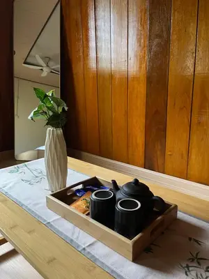 a tray with two cups on a table with a vase at Manson Goat Cottage in Cameron Highlands