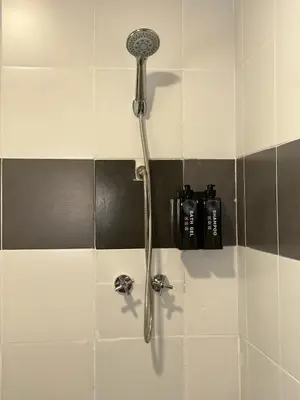 a shower with a shower head in a bathroom at Manson Goat Cottage in Cameron Highlands