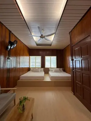 a room with two beds and a ceiling fan at Manson Goat Cottage in Cameron Highlands