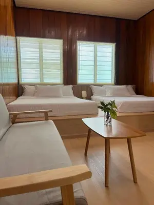 a room with four beds and a table at Manson Goat Cottage in Cameron Highlands