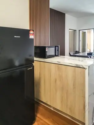 a kitchen with a black refrigerator and a counter at Sunrise Serenity at Palas Horizon Residence in Brinchang