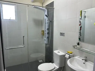 a bathroom with a shower and a toilet and a sink at Hazel Luxe Apartment in Permatang Pauh
