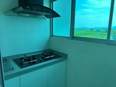 a kitchen with a stove and a window with a view at Hazel Luxe Apartment in Permatang Pauh