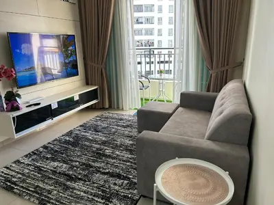 a living room with a couch and a flat screen tv at Hazel Luxe Apartment in Permatang Pauh