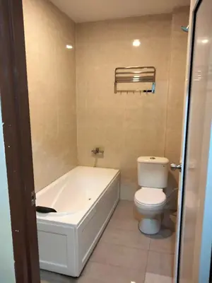 a bathroom with a white tub and a toilet at LE dEON HOTEL Former Pine Hotel in Batu Gajah
