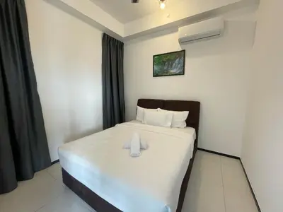 a bedroom with a bed with a towel on it at 3B2R 2CarPark Tea Time Suite with Infinity Pool in Jelutong