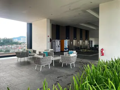 a lobby with chairs and tables on a balcony at 3B2R 2CarPark Tea Time Suite with Infinity Pool in Jelutong