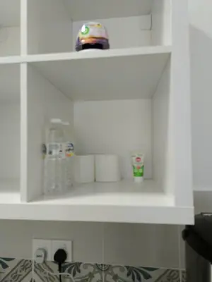 a white shelf with toilet paper and a toy on it at Dream Anderson Condo in Ipoh