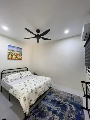 a bedroom with a bed and a ceiling fan at mOmma's Homestay in Seri Iskandar