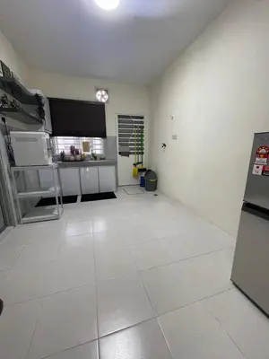 a large kitchen with white tile flooring in a room at mOmma's Homestay in Seri Iskandar