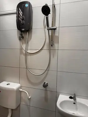 a bathroom with a phone on the wall next to a toilet at Mia homestay in Teluk Intan
