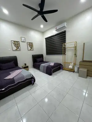 a bedroom with two beds and a ceiling fan at Mia homestay in Teluk Intan