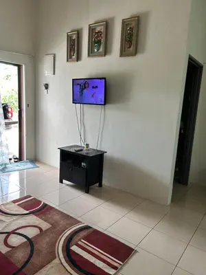 a living room with a tv on a wall at AMRI KLATE Homestay in Seri Iskandar
