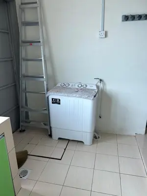 a kitchen with a stove in the corner of a room at AMRI KLATE Homestay in Seri Iskandar