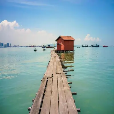 a dock with a red house in the water at The CEO Executive Suites in Bayan Lepas