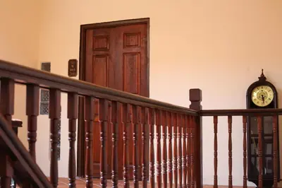 a clock on the wall next to a wooden door at LINN House Peranakan Residence George Town in George Town
