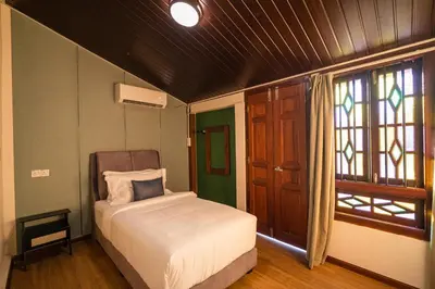 a small bedroom with a bed and a window at LINN House Peranakan Residence George Town in George Town